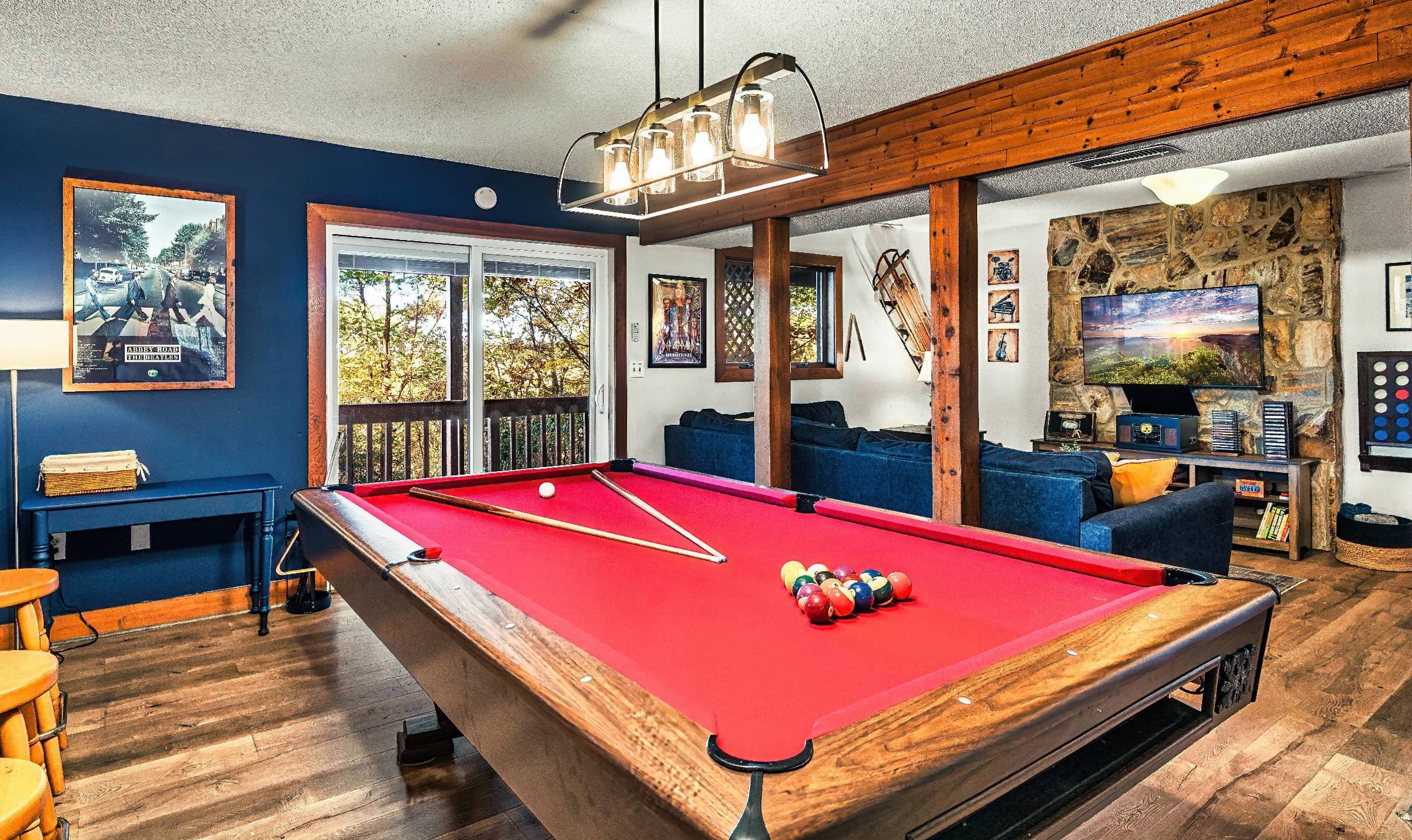 The music-themed lower level has a pool table, foosball table, sectional sofa, 50" Roku TV, connect 4 game, board games, 60-in-1 multicade game, music posters on the wall, & a Victrola music player w/ albums, CDs, & cassettes.