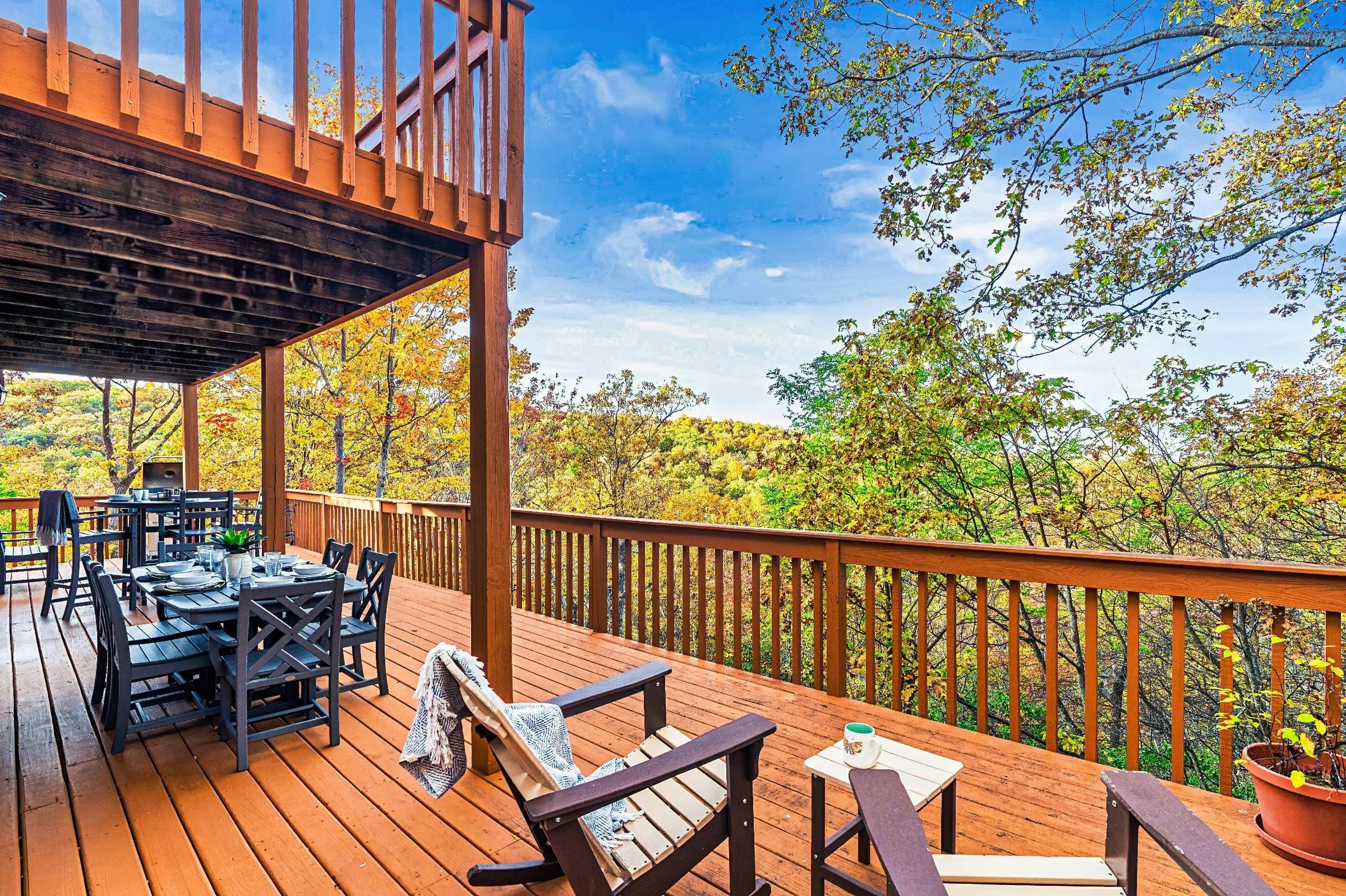 Covered deck with breathtaking mountain views. Features both a gas grill, large dining table, a high-top bistro table which are both ideal for meals, coffee, or relaxing with the scenic backdrop of the changing leaves, & 2 additional chairs & table.