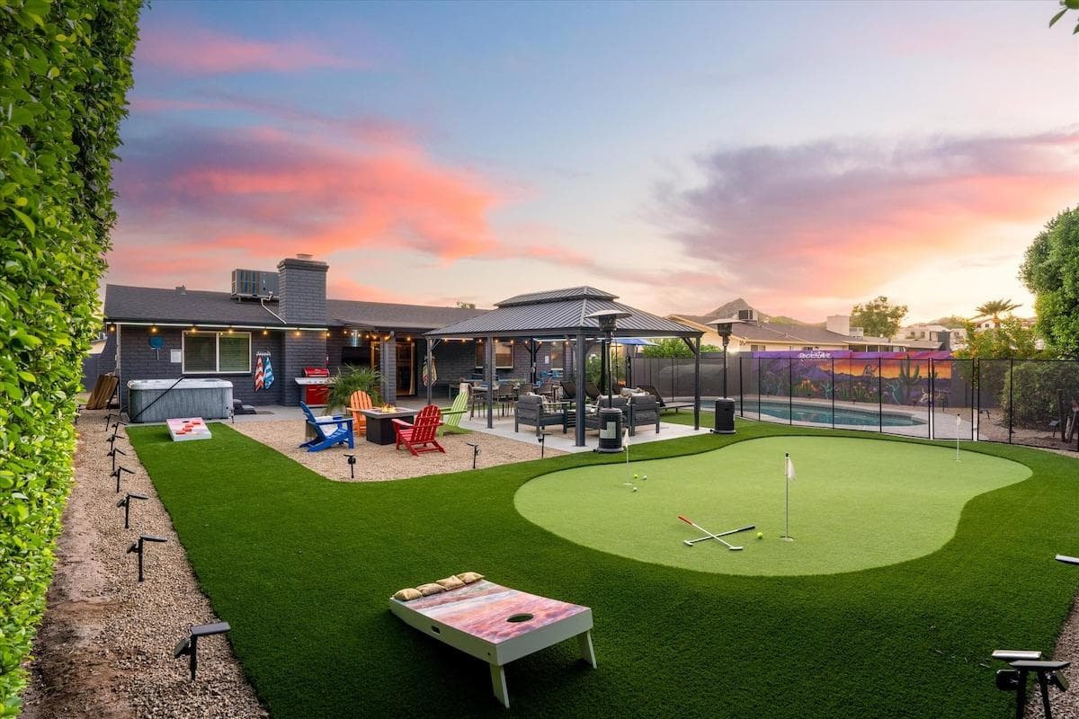 "Rockstar Paradise" backyard complete with a custom mural, hot tub, fire pit, gas grill, corn hole, 3 hole putting green, gazebo w/ outdoor dining table, 50 colored solar LED lights, patio heaters, ping pong table, and a heated pool w/ a safety gate